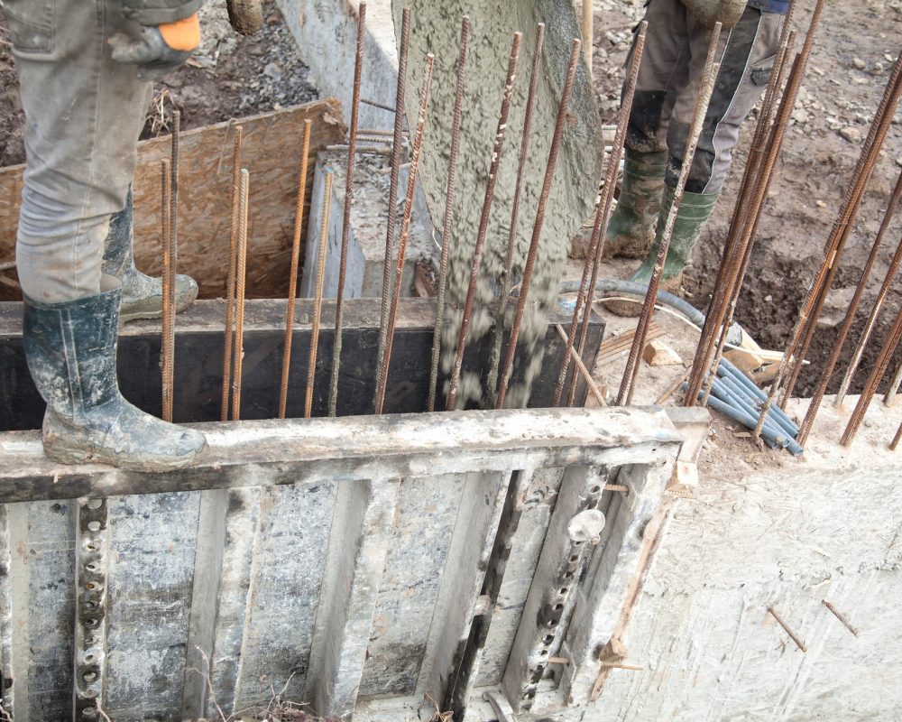 Pouring concrete into the construction of the house